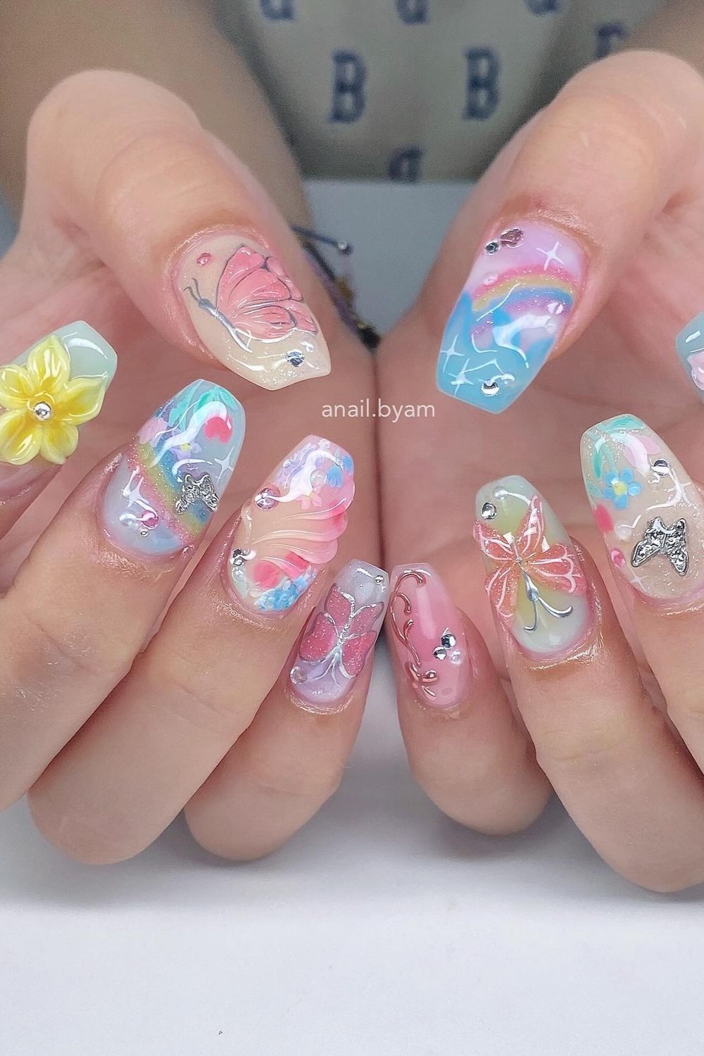 Summer Nails 2025 with pastel butterflies, rainbow, flowers, and sparkle.