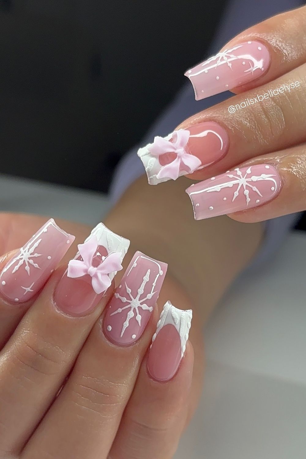 Want cute pink nails? See these pink nails with white bows and snowflakes for 2025!