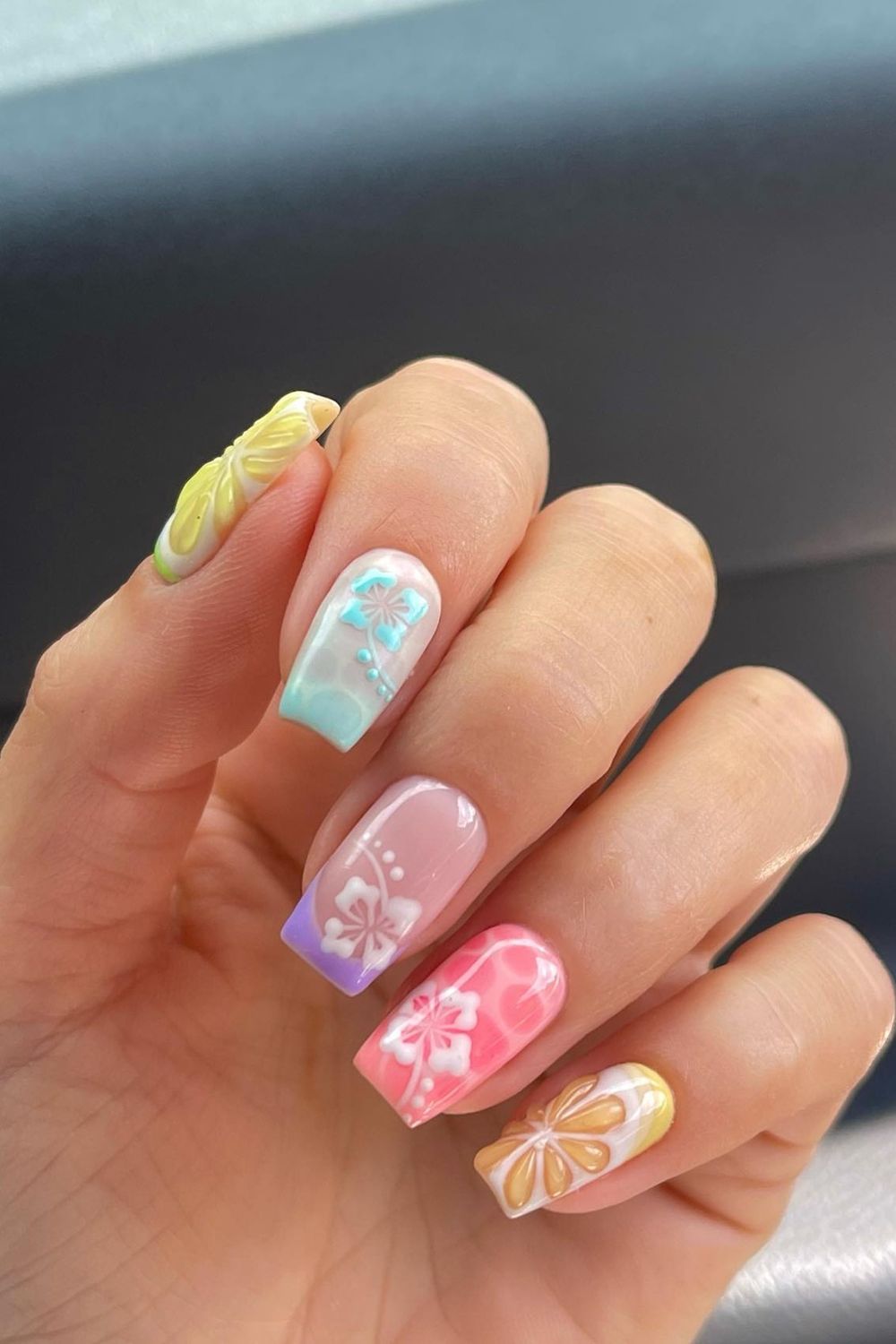 Colorful pastel summer nails with white 3D floral designs perfect for 2025.