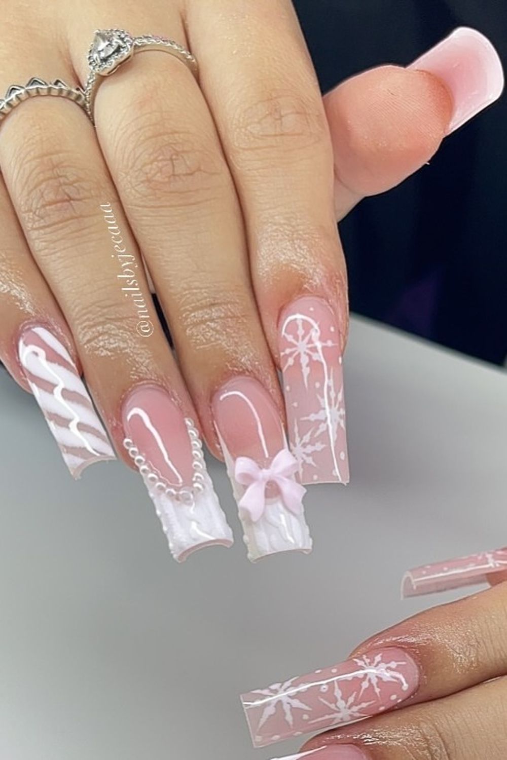 Want pretty pink nails? Check out these pink nails with white bows and snowflakes!  Find your perfect pink nail design now.